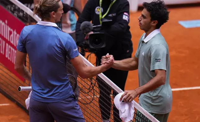 On the left, Alexander Zverev, of Germany, shakes hands with Francisco Cerundolo, of Argentina, during the Mutua Madrid Open tennis tournament in Madrid, Tuesday, April 30, 2024. (AP Photo/Manu Fernandez)