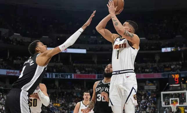 Denver Nuggets forward Michael Porter Jr., right, shoots over San Antonio Spurs center Victor Wembanyama during the first half of an NBA basketball game Tuesday, April 2, 2024, in Denver. (AP Photo/David Zalubowski)
