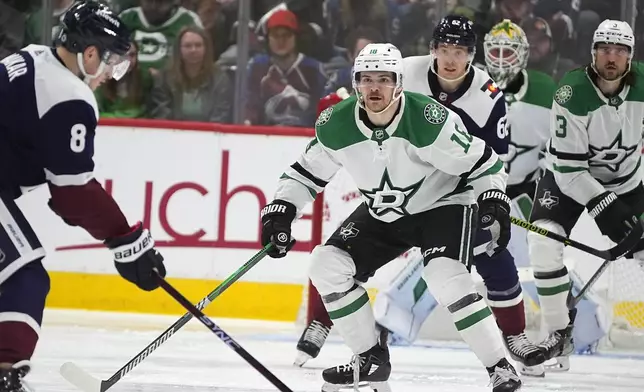 Dallas Stars center Sam Steel, right, drops back to block a shot by Colorado Avalanche defenseman Cale Makar (8) in the second period of an NHL hockey game Sunday, April 7, 2024, in Denver. (AP Photo/David Zalubowski)