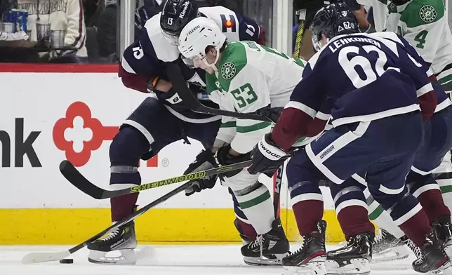 Dallas Stars center Wyatt Johnston (53) battles for control of the puck with Colorado Avalanche right wing Valeri Nichushkin, left, and left wing Artturi Lehkonen (62) in the second period of an NHL hockey game Sunday, April 7, 2024, in Denver. (AP Photo/David Zalubowski)