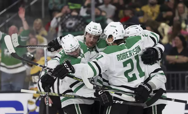 Dallas Stars defensemen Miro Heiskanen (4) and Thomas Harley (55) celebrate after center Wyatt Johnston, right, scored a goal against the Vegas Golden Knights during the first period in Game 3 of an NHL hockey Stanley Cup first-round playoff series Saturday, April 27, 2024, in Las Vegas. (AP Photo/Ian Maule)