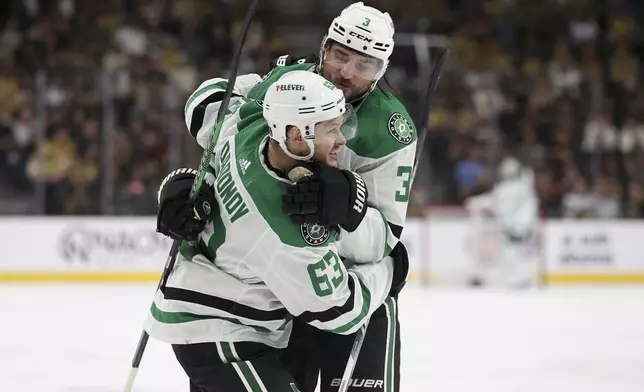 Dallas Stars right wing Evgenii Dadonov (63) and defenseman Chris Tanev (3) celebrate after Dadonov's goal during the first period against the Vegas Golden Knights in Game 4 of an NHL hockey Stanley Cup first-round playoff series Monday, April 29, 2024, in Las Vegas. (AP Photo/Ian Maule)