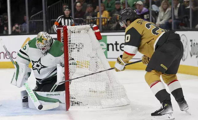 Dallas Stars goaltender Jake Oettinger (29) stops a shot by Vegas Golden Knights center Chandler Stephenson (20) during the second period in Game 3 of an NHL hockey Stanley Cup first-round playoff series Saturday, April 27, 2024, in Las Vegas. (AP Photo/Ian Maule)
