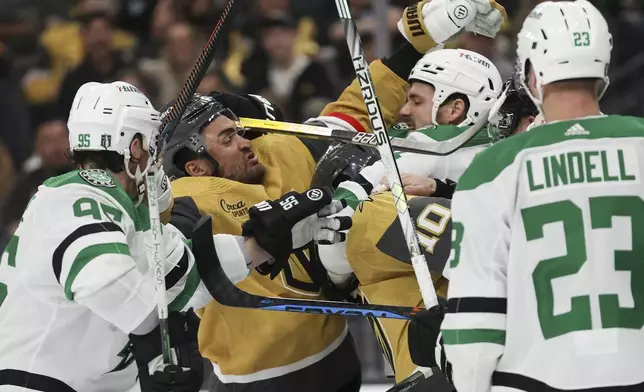 Vegas Golden Knights left wing William Carrier (28) and center Nicolas Roy (10) fight Dallas Stars left wing Jamie Benn (14) during the second period in Game 3 of an NHL hockey Stanley Cup first-round playoff series Saturday, April 27, 2024, in Las Vegas. (AP Photo/Ian Maule)