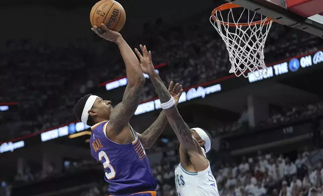 Phoenix Suns guard Bradley Beal (3) shoots over Minnesota Timberwolves guard Nickeil Alexander-Walker during the first half of Game 1 of an NBA basketball first-round playoff series, Saturday, April 20, 2024, in Minneapolis. (AP Photo/Abbie Parr)