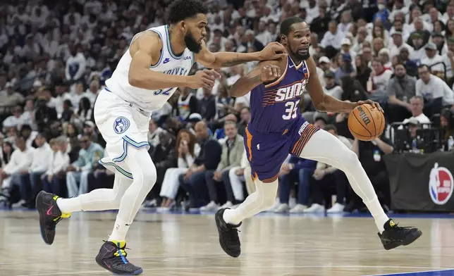 Phoenix Suns forward Kevin Durant, right, works toward the basket as Minnesota Timberwolves center Karl-Anthony Towns defends during the first half of Game 1 of an NBA basketball first-round playoff series, Saturday, April 20, 2024, in Minneapolis. (AP Photo/Abbie Parr)