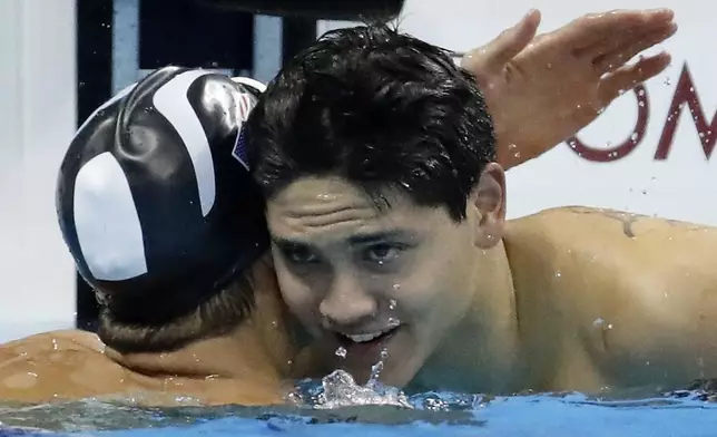 FILE - Singapore's Joseph Schooling, right, is congratulated by United States' Michael Phelps after winning the gold medal in the men's 100-meter butterfly final during the swimming competitions at the 2016 Summer Olympics, Friday, Aug. 12, 2016, in Rio de Janeiro, Brazil. Schooling, who beat Michael Phelps in the 100-meter butterfly to win Singapore's first and only Olympic gold medal at Rio de Janeiro in 2016, announced his retirement, Tuesday, April 2, 2024. (AP Photo/Dmitri Lovetsky, File)
