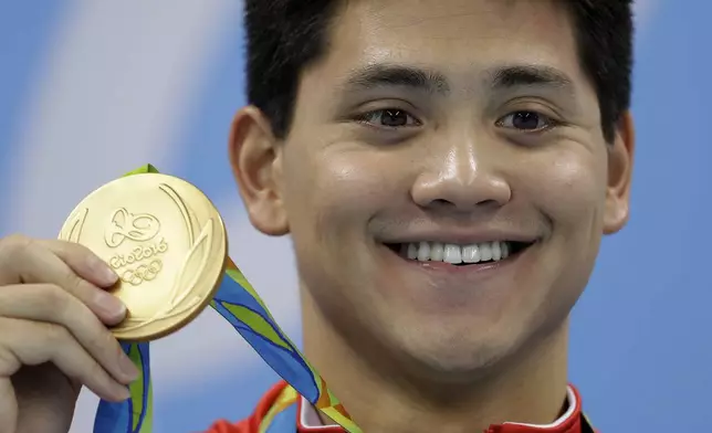 FILE - Singapore's Joseph Schooling shows off his gold medal in the men's 100-meter butterfly medals ceremony during the swimming competitions at the 2016 Summer Olympics, Friday, Aug. 12, 2016, in Rio de Janeiro, Brazil. Schooling, who beat Michael Phelps in the 100-meter butterfly to win Singapore's first and only Olympic gold medal at Rio de Janeiro in 2016, announced his retirement, Tuesday, April 2, 2024. (AP Photo/Michael Sohn, File)