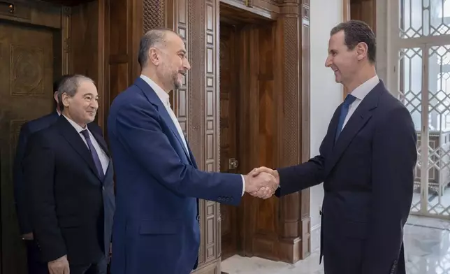 In this photo released on the official Telegram page of the Syrian Presidency, Syrian President Bashar Assad, right, welcomes Iranian Foreign Minister Hossein Amirabdollahian before their meeting in Damascus, Syria, Monday, April 8, 2024. Iran's foreign minister Monday accused the United States of giving Israel the "green light" to strike its consulate building in Syria that killed seven Iranian military officials including two generals. (Syrian Presidency Telegram page via AP)