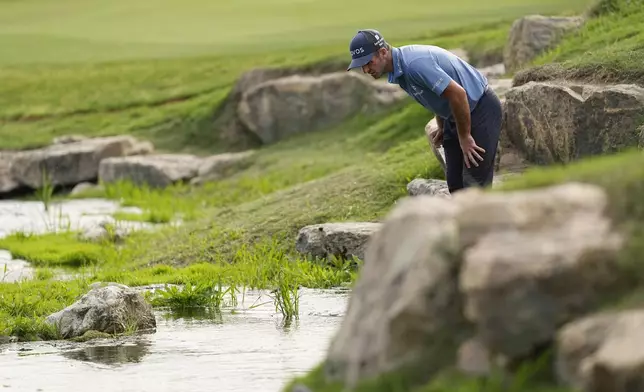 Denny McCarthy looks for his ball in a creek on the 18th hole during during a playoff with Akshay Bhatia in the Texas Open golf tournament, Sunday, April 7, 2024, in San Antonio. (AP Photo/Eric Gay)