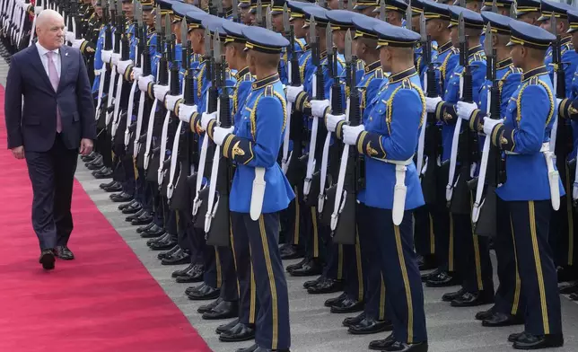 New Zealand's Prime Minister Christopher Luxon, left, reviews an honor guard during a welcome ceremony at the government house in Bangkok, Thailand, Wednesday, April 17, 2024. (AP Photo/Sakchai Lalit)