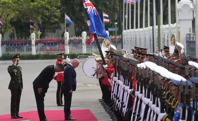 Thailand's Prime Minister Srettha Thavisin, second left, and New Zealand's Prime Minister Christopher Luxon, third left, bow in front of Thailand and New Zealand national flags during a welcome ceremony at the government house in Bangkok, Thailand, Wednesday, April 17, 2024. (AP Photo/Sakchai Lalit)