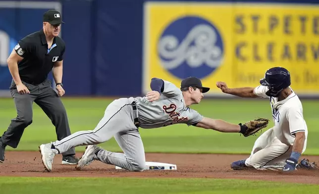 Detroit Tigers second baseman Colt Keith, center, tags out Tampa Bay Rays' Amed Rosario, right, attempting to steal second base during the first inning of a baseball game Monday, April 22, 2024, in St. Petersburg, Fla. Making the call is umpire Ryan Blakney. (AP Photo/Chris O'Meara)