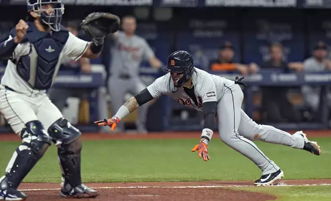 Detroit Tigers' Javier Baez scores in front of Tampa Bay Rays catcher Rene Pinto, left, on a throwing error by Jose Caballero during the fifth inning of a baseball game Monday, April 22, 2024, in St. Petersburg, Fla. (AP Photo/Chris O'Meara)