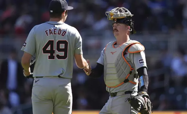 Detroit Tigers pitcher Alex Faedo (49) and catcher Jake Rogers, right, shake hands after their win over the Minnesota Twins of a baseball game Sunday, April 21, 2024, in Minneapolis. (AP Photo/Abbie Parr)