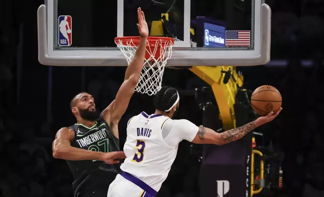 Minnesota Timberwolves center Rudy Gobert, left, defends against Los Angeles Lakers forward-center Anthony Davis (3) during the first half of an NBA basketball game, Sunday, April 7, 2024, in Los Angeles. (AP Photo/Etienne Laurent)