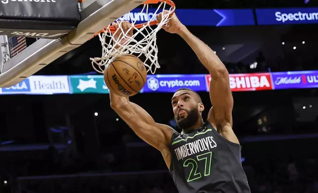 Minnesota Timberwolves center Rudy Gobert (27) scores during the first half of an NBA basketball game against the Los Angeles Lakers, Sunday, April 7, 2024, in Los Angeles. (AP Photo/Etienne Laurent)