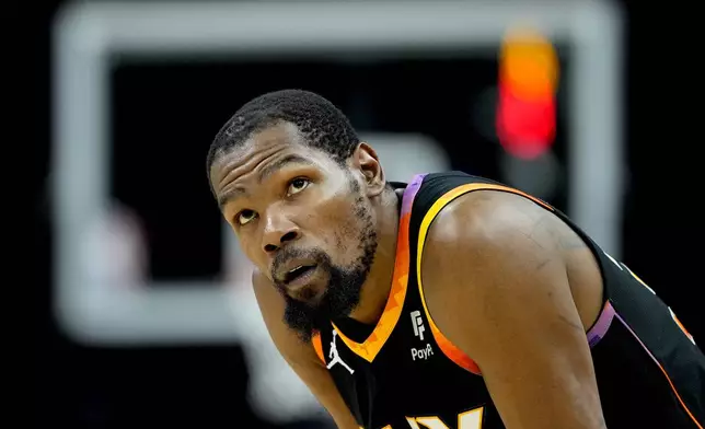 Phoenix Suns forward Kevin Durant looks at the scoreboard during the second half of Game 3 of an NBA basketball first-round playoff series against the Minnesota Timberwolves, Friday, April 26, 2024, in Phoenix. (AP Photo/Matt York)