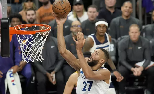 Minnesota Timberwolves center Rudy Gobert scores against the Phoenix Suns during the first half of Game 4 of an NBA basketball first-round playoff series, Sunday, April 28, 2024, in Phoenix. (AP Photo/Ross D. Franklin)