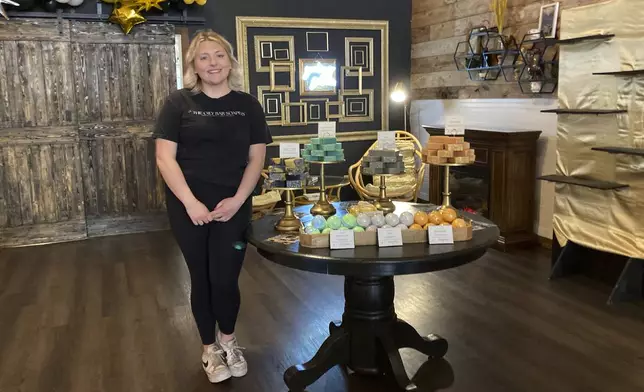 Kalee Hume stands alongside her handmade eclipse-themed soaps at her shop in downtown Waxahachie, Texas, on Saturday, April 6, 2024. Waxahachie will be in the path of totality for Monday's eclipse of the sun. (AP Photo/Marcia Dunn)