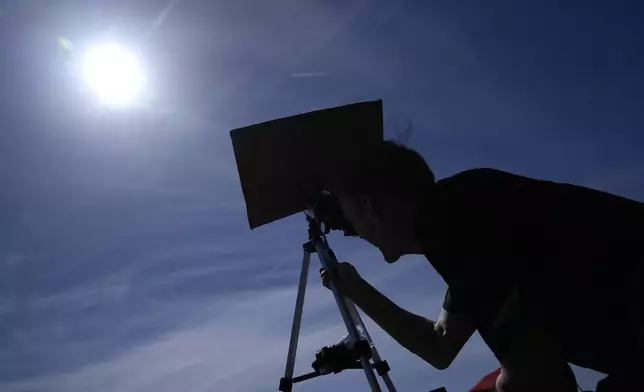 Mike Porter uses a telescope to get a look at the sun as he prepares to watch a total solar eclipse Monday, April 8, 2024, in Carbondale, Ill. (AP Photo/Jeff Roberson)