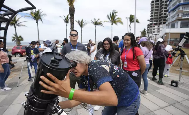 An amateur astronomer prepares her telescope a day before a total solar eclipse in Mazatlan, Mexico, Sunday, April 7, 2024. (AP Photo/Fernando Llano)