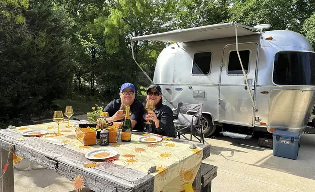 Jeff Pappas and his wife, Maribeth Messineo Pappas, pose by their Airstream trailer at the Range Vintage Trailer Resort near Ennis, Texas, Sunday, April 7, 2024. The couple lives in Dallas but wanted to watch the eclipse from the resort about 30 miles away. Messineo Pappas said they often stay at the resort, which she said is a “magical place” on an average day, so they thought being there for the eclipse would be really special. (AP Photo/Jamie Stengle)