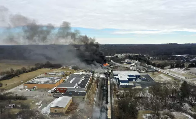 FILE - This photo taken with a drone shows portions of a Norfolk and Southern freight train that derailed Friday night in East Palestine, Ohio are still on fire at mid-day Saturday, Feb. 4, 2023. On Tuesday, April 9, 2024, Norfolk Southern has agreed to pay $600 million in a class-action lawsuit settlement related to a fiery train derailment in February 2023 in eastern Ohio. (AP Photo/Gene J. Puskar, File)