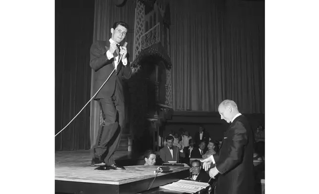 FILE - Eddie Fisher uses the top of a grand piano as a stage to entertain 500 Las Vegans in a local preview debut of his first Las Vegas appearance, April 1957. He will formally open the new Hotel Tropicana with a cast of 50 performers. (AP Photo, File)