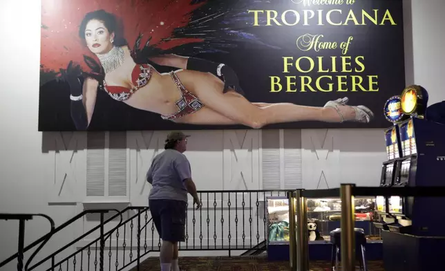 FILE - In this Jan. 15, 2009, file photo a man walks past a sign promoting Les Folies Bergere show at the Tropicana in Las Vegas. (AP Photo/Jae C. Hong,File)