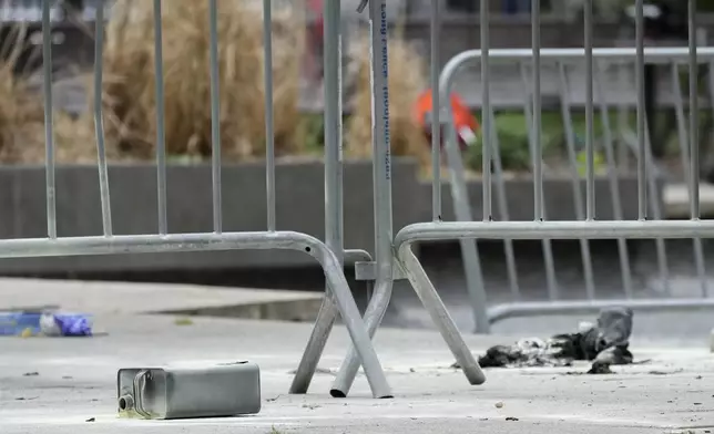 A metal can sits on the ground at the scene where a man lit himself on fire in a park outside Manhattan criminal court, Friday, April 19, 2024, in New York. Emergency crews rushed away a person on a stretcher after fire was extinguished outside the Manhattan courthouse where jury selection was taking place Friday in Donald Trump's hush money criminal case. (AP Photo/Mary Altaffer)