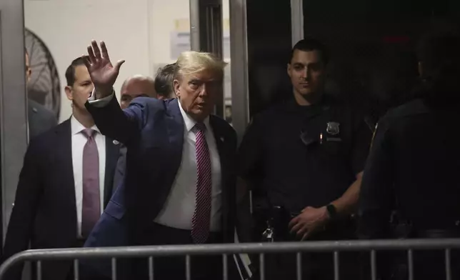 Former President Donald Trump waves as he enters Manhattan Criminal Court on Friday, April 19, 2024 in New York. (Spencer Platt/Pool Photo via AP)