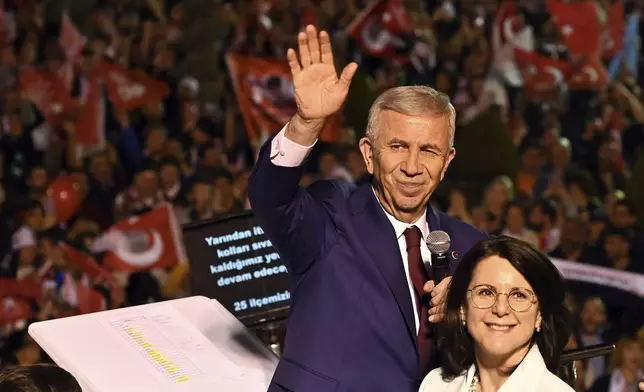 Ankara's Mayor and Republican People's Party, or CHP, candidate Mansur Yavas gestures as he addresses to supporters next to his wife Nursen Yavas, in Ankara, Turkey, Sunday, March 31, 2024. (AP Photo/Ali Unal)