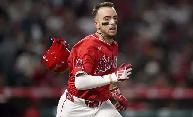 Los Angeles Angels' Zach Neto loses his helmet while running to first after grounding out to Minnesota Twins shortstop Willi Castro during the fourth inning of a baseball game Saturday, April 27, 2024, in Anaheim, Calif. (AP Photo/Ryan Sun)