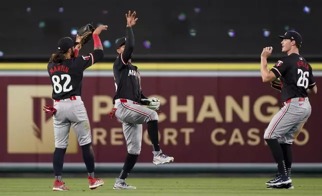 Minnesota Twins left fielder Austin Martin, center fielder Byron Buxton and right fielder Max Kepler, from left, celebrate the team's win against the Los Angeles Angels in a baseball game, Friday, April 26, 2024, in Anaheim, Calif. (AP Photo/Ryan Sun)