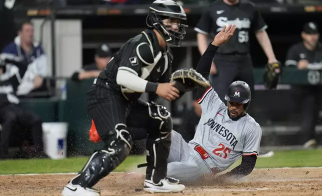 Minnesota Twins center fielder Byron Buxton, right, slides into home past Chicago White Sox catcher Korey Lee, left, to score on a single by Max Kepler during the ninth inning of a baseball game Monday, April 29, 2024, in Chicago. (AP Photo/Erin Hooley)
