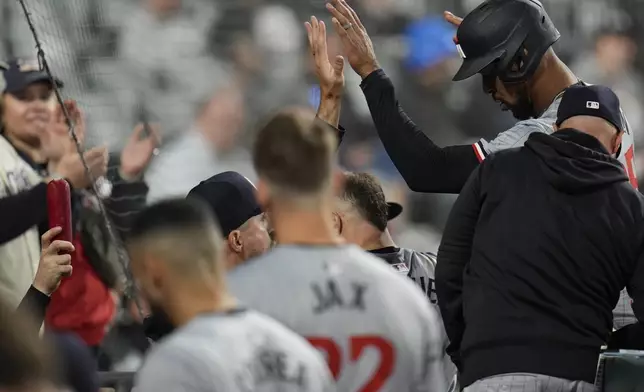 A sausage, left, is held up as Minnesota Twins center fielder Byron Buxton, top right, enters the dugout after scoring on a single by Max Kepler during the ninth inning of a baseball game against the Chicago White Sox, Monday, April 29, 2024, in Chicago. (AP Photo/Erin Hooley)