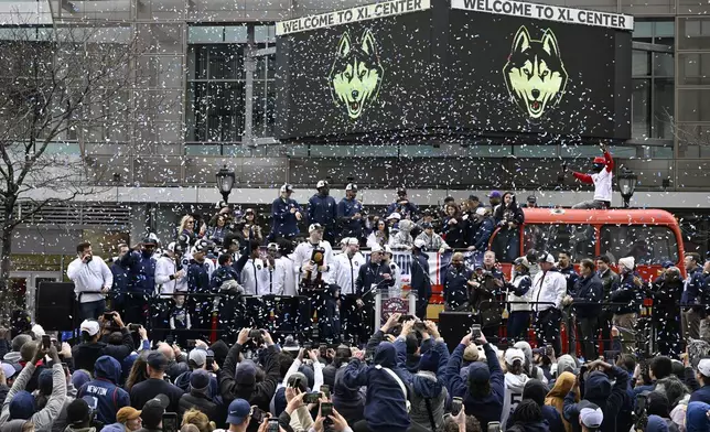 Confetti falls on the UConn men's basketball team during a parade to celebrate the team's NCAA college basketball championship, Saturday, April 13, 2024, in Hartford, Conn. (AP Photo/Jessica Hill)