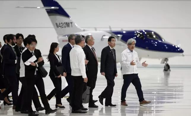 Japanese Prime Minister Fumio Kishida, second from right, walks through the assembly building during a visit to the Honda Aircraft facility in Greensboro, N.C., Friday, April 12, 2024. (AP Photo/Chuck Burton)