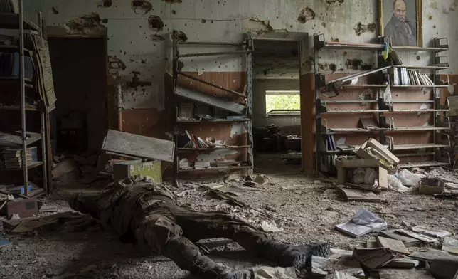 FILE - The body of a Russian soldier lies inside a building in the village of Blahodatne, Ukraine, Saturday, June 17, 2023. (AP Photo/Evgeniy Maloletka, File)