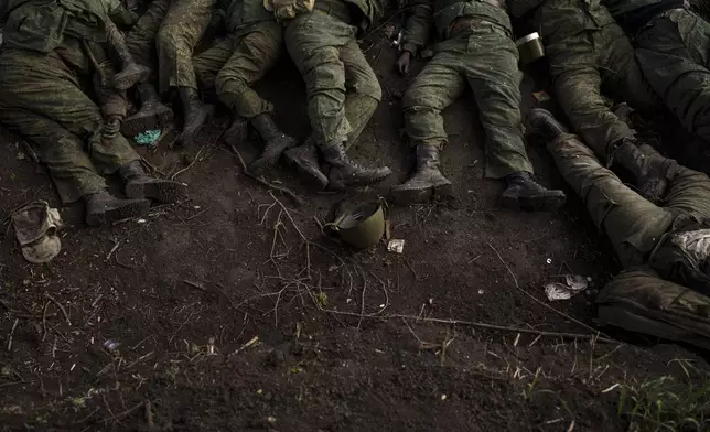 FILE - The bodies of 11 Russian soldiers lie on the ground in the village of Vilkhivka, recently retaken by Ukrainian forces near Kharkiv, Ukraine, Monday, May 9, 2022. More than half a million people have been killed or seriously injured in two years of war in Ukraine, according to Western intelligence estimates -- a human toll not seen in Europe since World War II. (AP Photo/Felipe Dana, File)