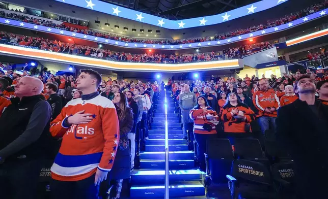 FILE - Fans stand for the national anthem in the Capital One Arena before an NHL hockey game between the Washington Capitals and the New Jersey Devils, Tuesday, Feb. 20, 2024, in Washington. The NBA’s Washington Wizards and NHL’s Washington Capitals are staying in the District of Columbia. Owner Ted Leonsis and Mayor Muriel Bowser announced the development at a news conference at Capital One Arena on Wednesday, March 27, 2024. (AP Photo/Alex Brandon, File)