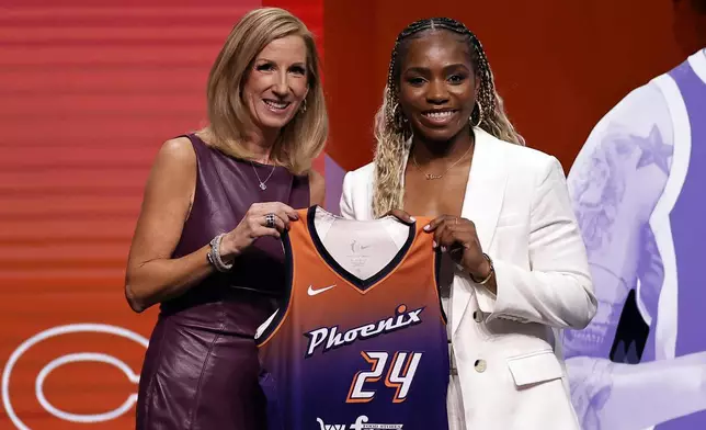 UCLA's Charisma Osborne, right, poses for a photo with WNBA commissioner Cathy Engelbert, left, after being selected 25th overall by the Phoenix Mercury during the third round of the WNBA basketball draft on Monday, April 15, 2024, in New York. (AP Photo/Adam Hunger)
