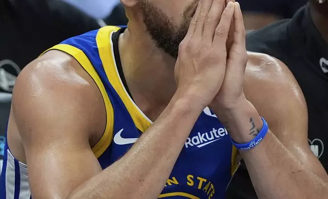 Golden State Warriors guard Stephen Curry sits on the bench during the second half of the team's NBA basketball play-in tournament game against the Sacramento Kings, Tuesday, April 16, 2024, in Sacramento, Calif. (AP Photo/Godofredo A. Vásquez)