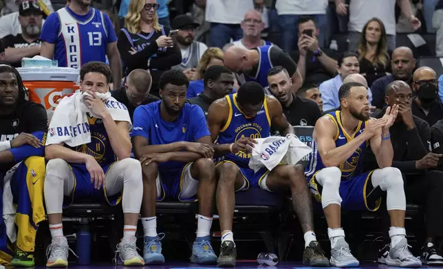 Golden State Warriors guards Klay Thompson, second from left, and Stephen Curry, second from right, sit on the bench during the second half of the team's NBA basketball play-in tournament game against the Sacramento Kings, Tuesday, April 16, 2024, in Sacramento, Calif. (AP Photo/Godofredo A. Vásquez)
