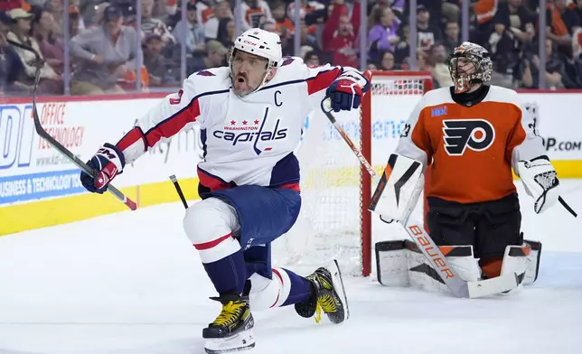 Washington Capitals' Alex Ovechkin, left, reacts after scoring a goal against Philadelphia Flyers' Samuel Ersson during the first period of an NHL hockey game, Tuesday, April 16, 2024, in Philadelphia. (AP Photo/Matt Slocum)