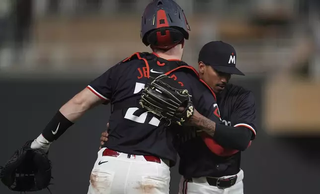 Minnesota Twins catcher Ryan Jeffers, left, and relief pitcher Ronny Henriquez, right, hug after a win over the Chicago White Sox in a baseball game Monday, April 22, 2024, in Minneapolis. (AP Photo/Abbie Parr)