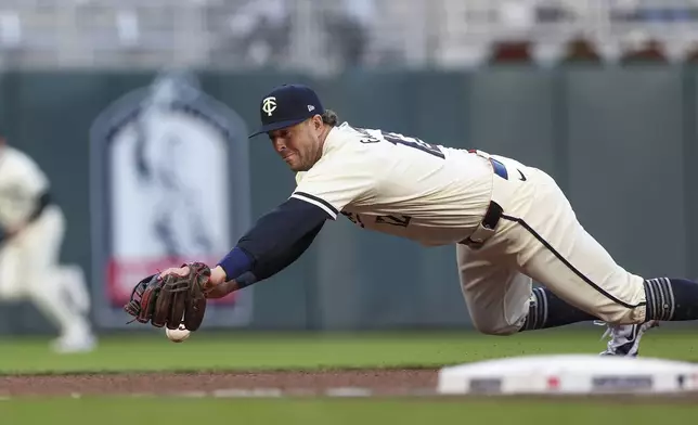 Minnesota Twins third base Kyle Farmer misses a ground ball hit by Chicago White Sox's Danny Mendick for a single during the fourth inning of a baseball game Tuesday, April 23, 2024, in Minneapolis. (AP Photo/Stacy Bengs)