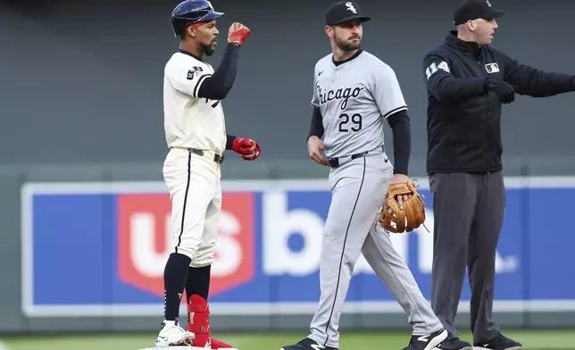 Minnesota Twins' Byron Buxton reacts at second base after hitting a double, next to Chicago White Sox shortstop Paul DeJone during the first inning of a baseball game Tuesday, April 23, 2024, in Minneapolis. (AP Photo/Stacy Bengs)