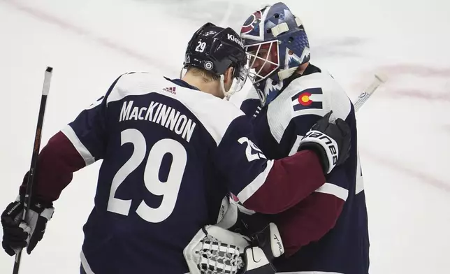 Colorado Avalanche center Nathan MacKinnon (29) and goaltender Alexandar Georgiev (40) congratulate each other after an NHL hockey game against the Minnesota Wild Tuesday, April 9, 2024, in Denver. (AP Photo/Bart Young)